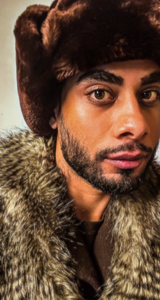 Portrait of Artan Davoodi wearing a brown winter hat and a fur-trimmed coat